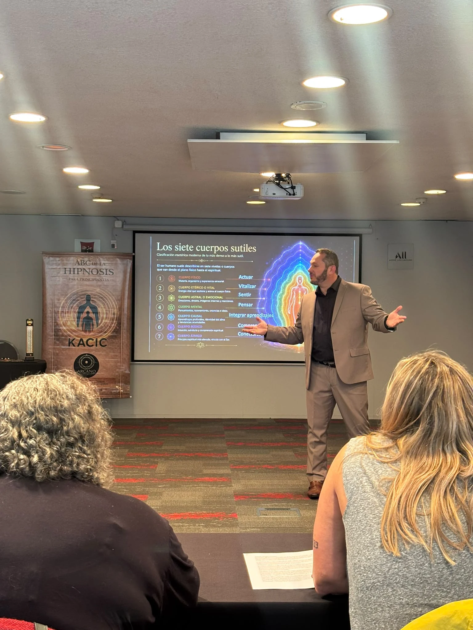 Maikel impartiendo una clase presencial frente a los participantes
